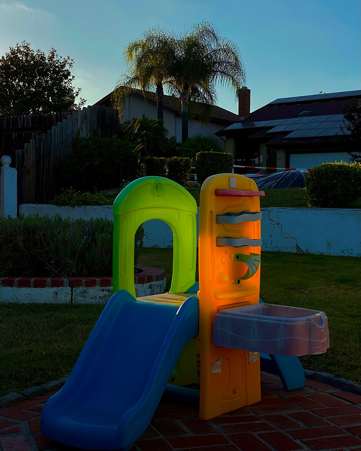 A spot of evening sun shining through a plastic toddler slide, making it appear to glow.